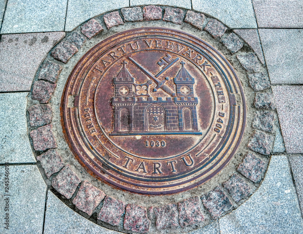 Circular manhole cover in the historical center of Tartu, Estonia