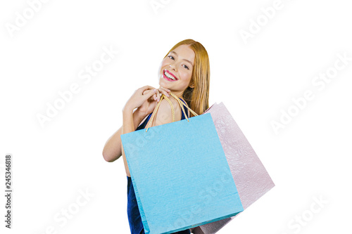 A young girl with long red hair holds two bags over her shoulder with new purchases worth a half turn and smiles into the camera, closeup photo © Oleksandr