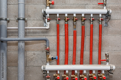 Pipes of heating and water supply system on the background of a concrete wall. photo