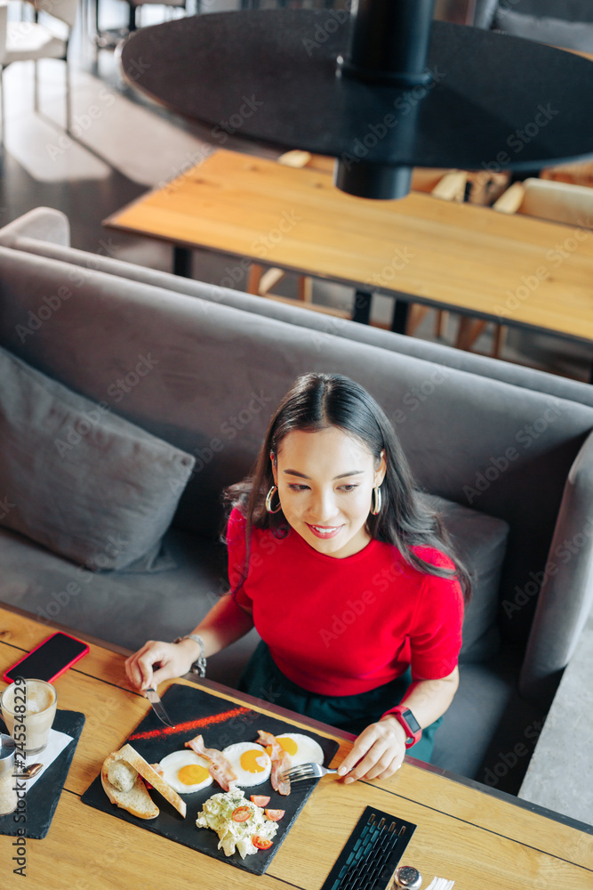 Top view of appealing young woman having tasty breakfast in restaurant Top view of appealing young woman having tasty breakfast in restaurant