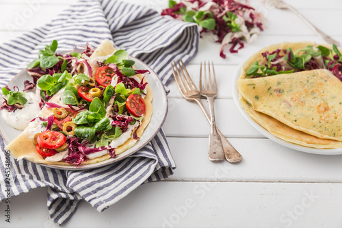 hearty pancakes with fresh salad, tomato and radicchio