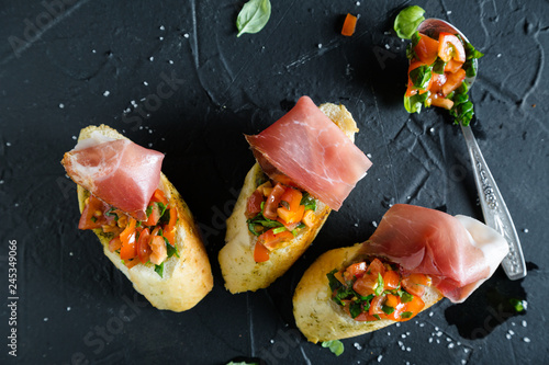 Bruschetta with prosciutto, tomatoes and basil