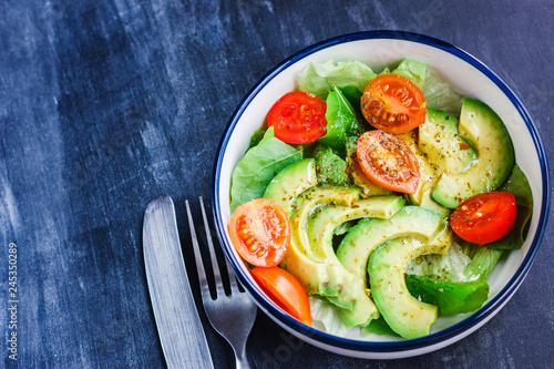 Vegetarian salad with avocado, arugula, cherry tomatoes and herbs.