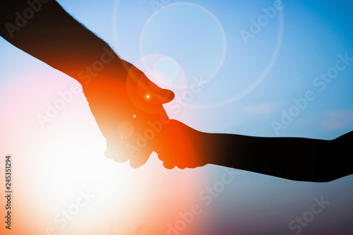 happy parent father with baby hand silhouette at sunset in nature park