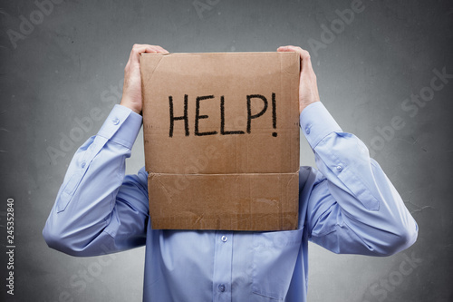 Cardboard box on businessman head ask for help
