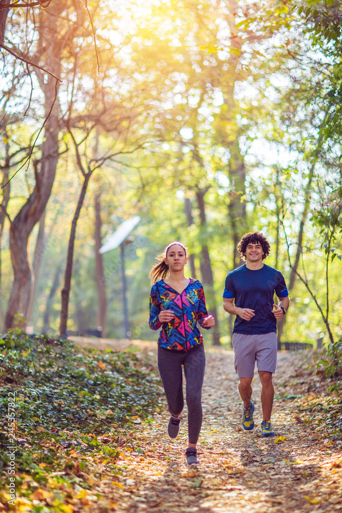 Cardio exercise - couple enjoying in a healthy lifestyle while jogging along a forest,. Cardio exercise - couple enjoying in a healthy lifestyle while jogging along a forest,.