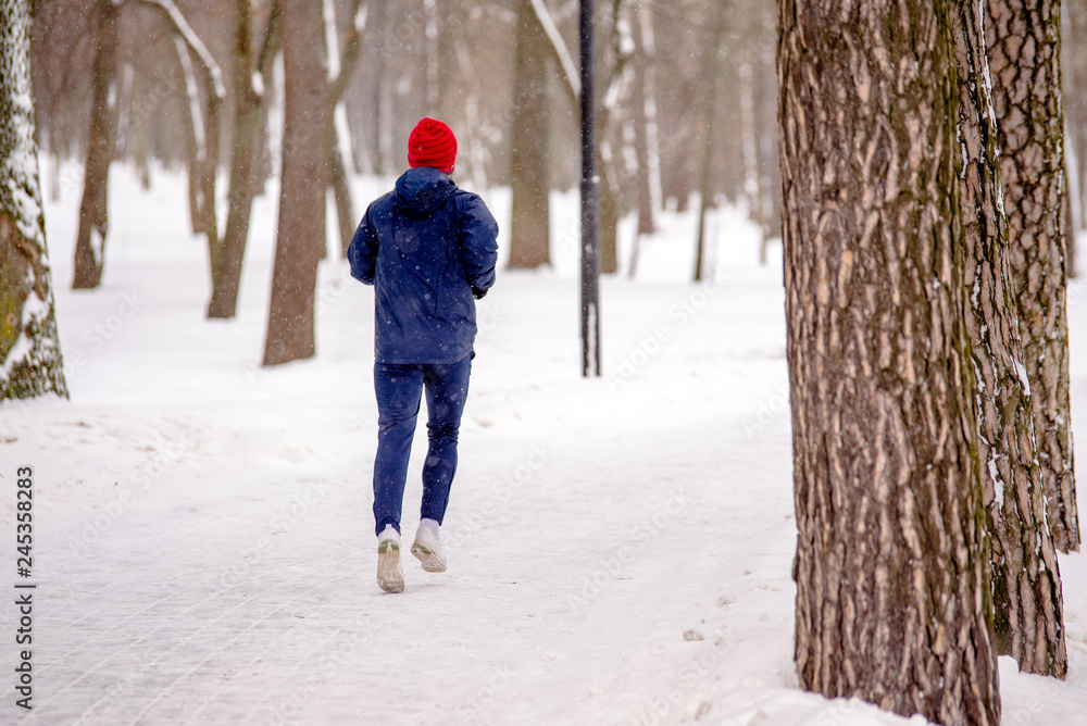 The athlete jogs in the Park in winter 