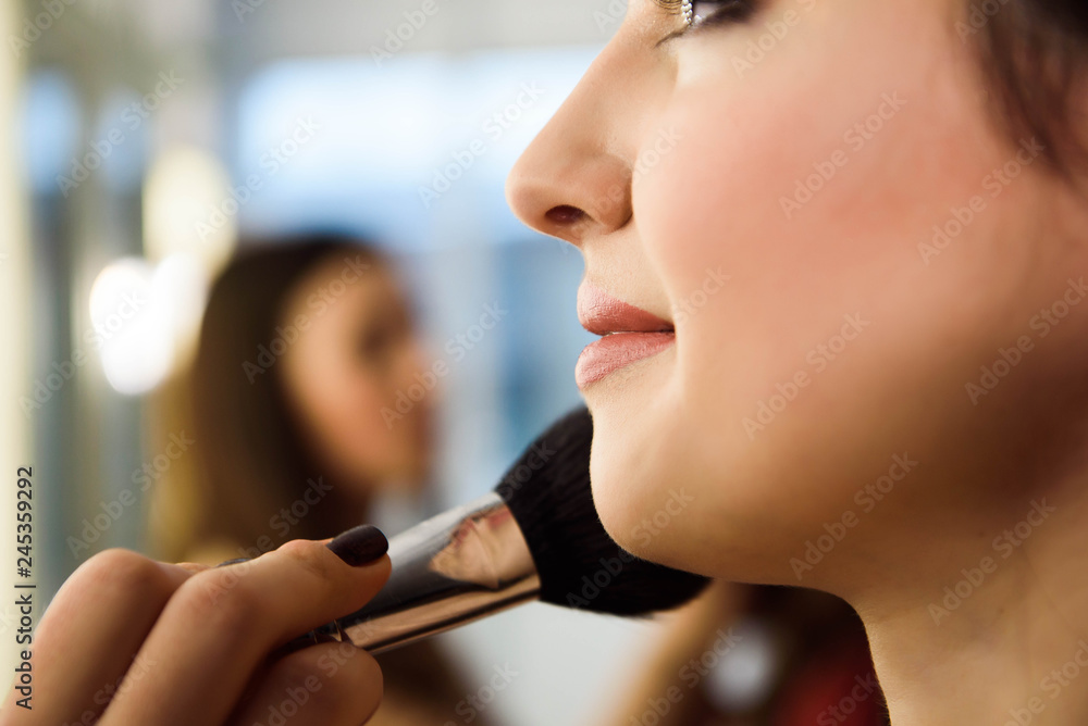 Beauty and health clean Skin of young female Model. Woman applying Powder Foundation with Brush.