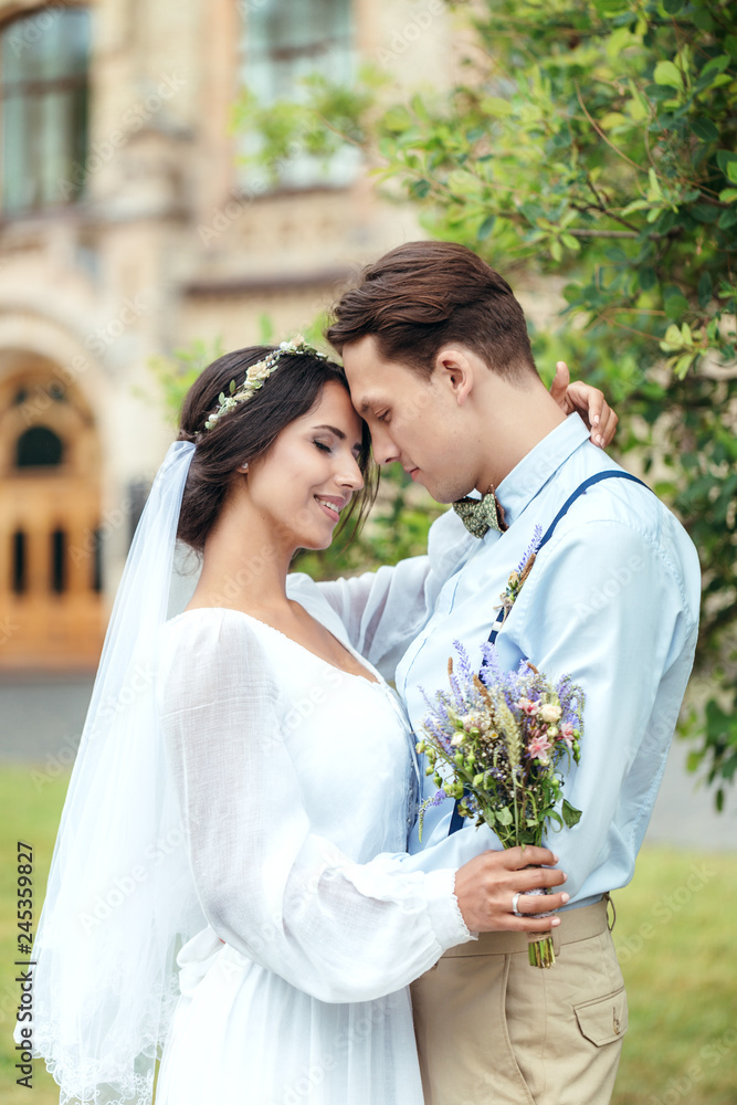 Naklejka premium The first walk of the newlyweds, walking hug, love each other. girl in her hands holding flowers