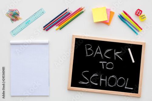Back to school concept desk with pencil, balckboard, notepad, ruler