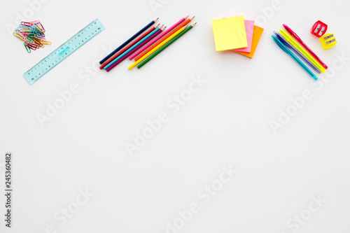 White desk with pencil, crayons, ruler, postit and blank space to fill