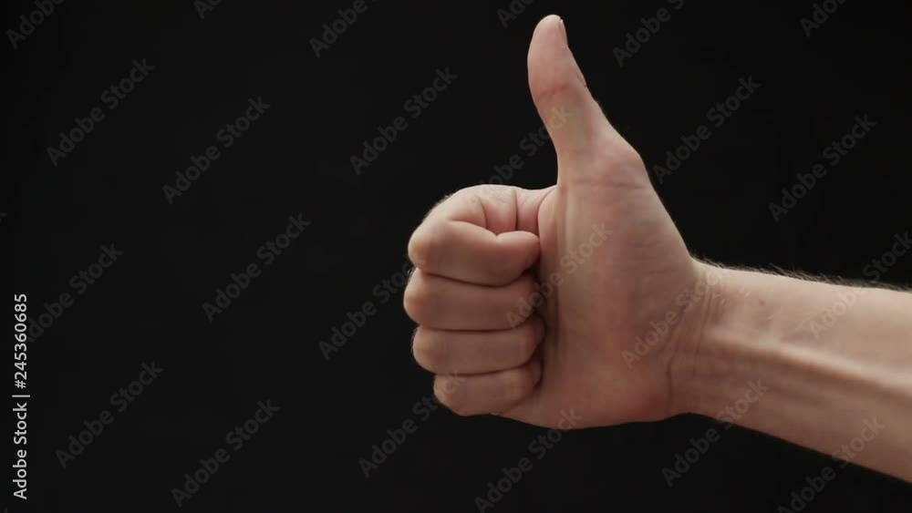 Man hand show thumbs up gesture on black background Man hand show thumbs up gesture on black background