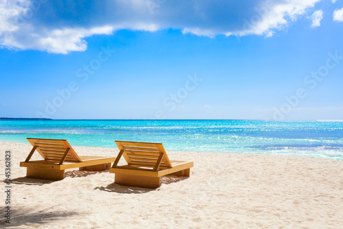 Vacation holidays background wallpaper - beach loungers without people in sunny tropical caribbean beach with white sand in dominican republic at island saona thailand style