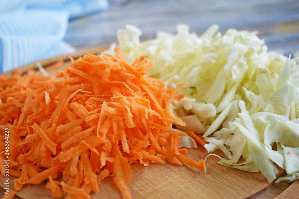 Sliced carrots and cabbage on a wooden Board.Food ingredient. Sliced carrots and cabbage on a wooden Board.Food ingredient.