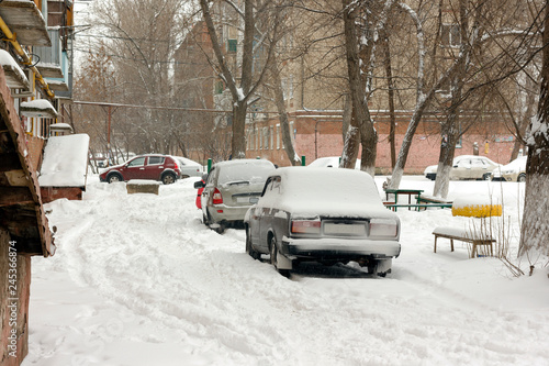row of cars parked in the snow