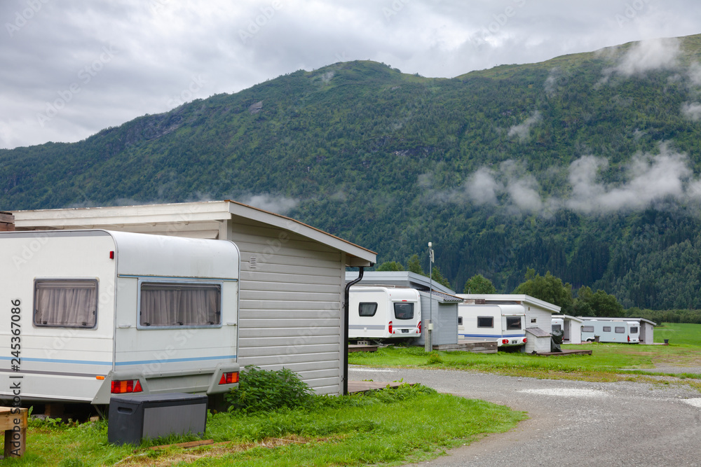Wooden camping cabins with camper trailers at a campsite in Norway Scandinavia Wooden camping cabins with camper trailers at a campsite in Norway Scandinavia
