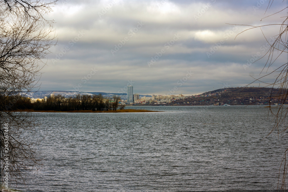 The city of Saratov can be seen in cloudy weather across the Volga River from the embankment of the city of Engels