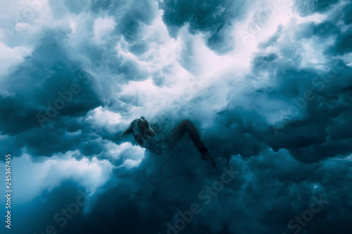 Photography Surfer girl with surfboard under wave. underwater wipeout
