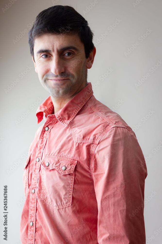 Medium shot of smiling young man with red shirt posing on studio. Handsome male model portrait over white background. Fashion, lifestyle, photo shoot concepts Medium shot of smiling young man with red shirt posing on studio. Handsome male model portrait over white background. Fashion, lifestyle, photo shoot concepts