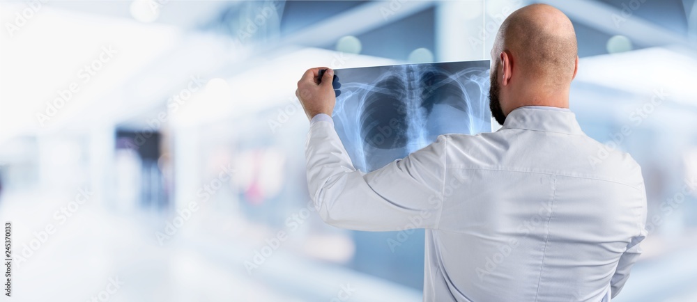 Portrait of young doctor man holding x-ray of human breast Portrait of young doctor man holding x-ray of human breast