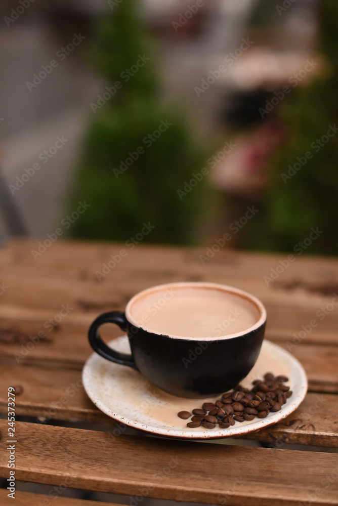 Cup of coffee with coffee beans on a wooden table