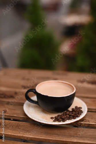 Cup of coffee with coffee beans on a wooden table