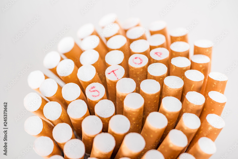 Studio shot of bunch of cigarettes isolated on grey, stop smoking concept Studio shot of bunch of cigarettes isolated on grey, stop smoking concept