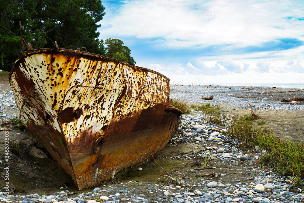 Rusty ship stranded aground on the beach with pebbles in the Black Sea. Rusty ship stranded aground on the beach with pebbles in the Black Sea.