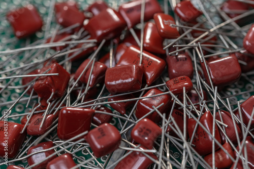 Electronic components, Lots of red film capacitors on PCB background photo