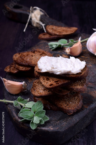 Rye bread toasts with lard paste on a black board. Ukrainian cuisine appetizer