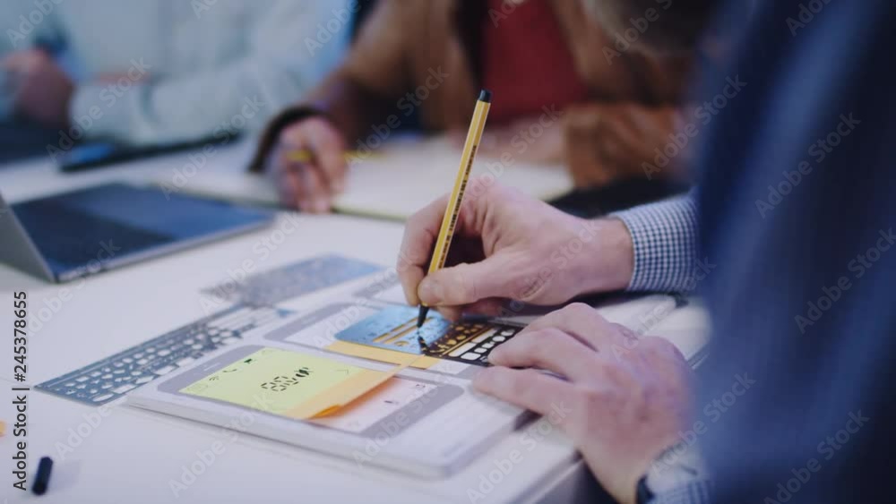 UX Designer, mobile app developer outlines an app on paper with template -UX Designer , Mobile App-Entwickler skizziert eine App auf Papier mit Schablone  4k PRORES Footage