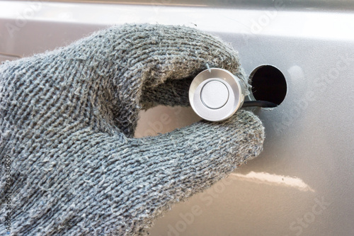 Close up of Hand with car ultrasonic parking sensor.