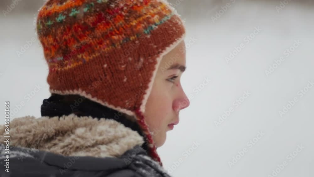 Portrait of boy face close up in snowfall. Child teenager looks at falling snow in winter.
Portrait of boy face close up in snowfall. Child teenager looks at falling snow in winter.
