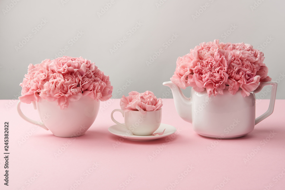 white cups and kettle with beautiful pink flowers on grey