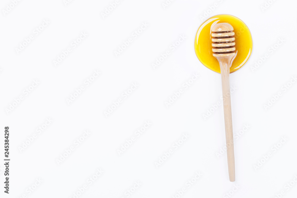 Honey dipper in honey and a jar of honey isolated on light grey background Honey dipper in honey and a jar of honey isolated on light grey background