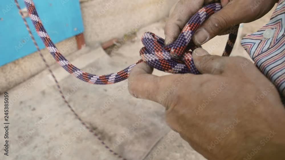 Extreme professional male rock climber attaching rope to his harness in ...