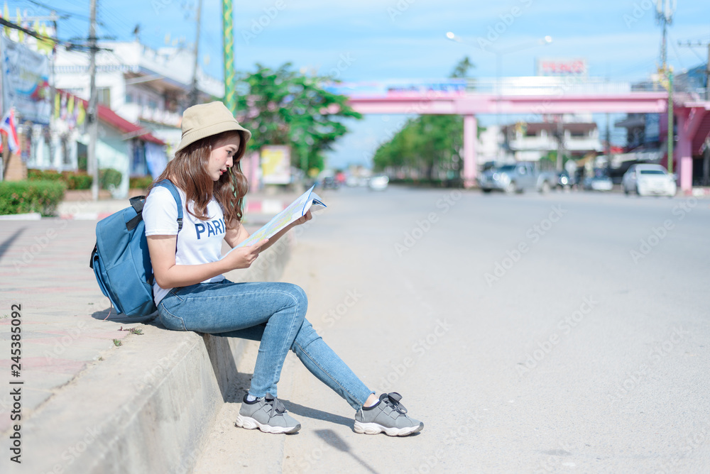 Fototapeta premium A woman is looking at a map for traveling,traveling in Thailand,traveling in Chiang mai