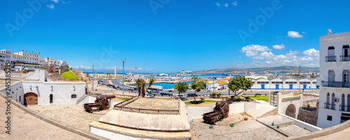 Ancient fortress with cannons and view of port and coastal structure in Tangier. Morocco