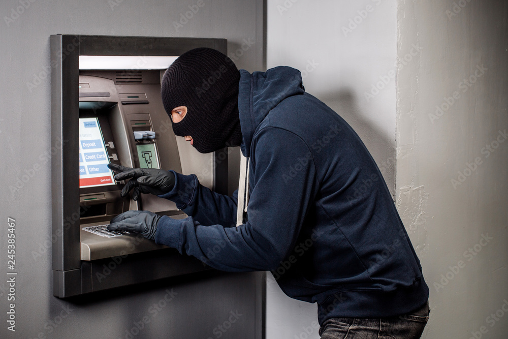 Hacker stealing password and identity on atm machine. Computer crime concept.