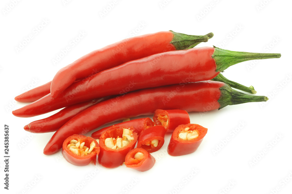 red rawit peppers (Capsicum annuum 'Bird's Eye') and a cut one on a white background
