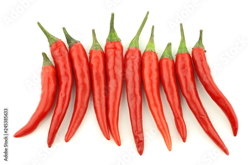 red rawit peppers (Capsicum annuum 'Bird's Eye') in a row on a white background