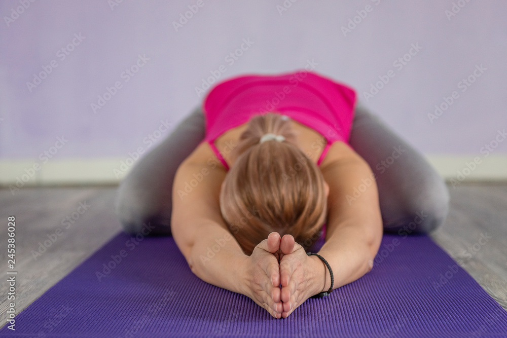 woman practicing excercising yoga on a mat woman practicing excercising yoga on a mat