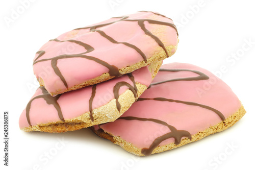 freshly baked pink glazed cakes with chocolate dressing on a white background