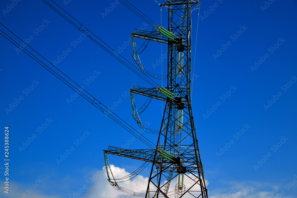 A transmission tower or electricity pylon with blue sky. It is a tall structure, usually a steel lattice tower, used to support an overhead power line. A transmission tower or electricity pylon with blue sky. It is a tall structure, usually a steel lattice tower, used to support an overhead power line.
