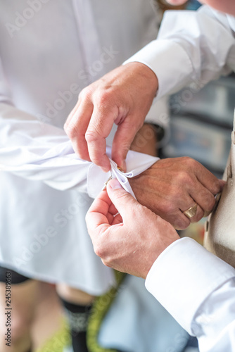 cufflinks fastened by groom at a wedding
