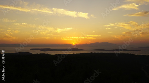 Sunset over sea at Devil's Table (Şeytan Sofrası). Bright dramatic sky and dark blue ground. Beautiful landscape under scenic colorful orange sky at sunset. Sun over skyline. Warm yellow color concept