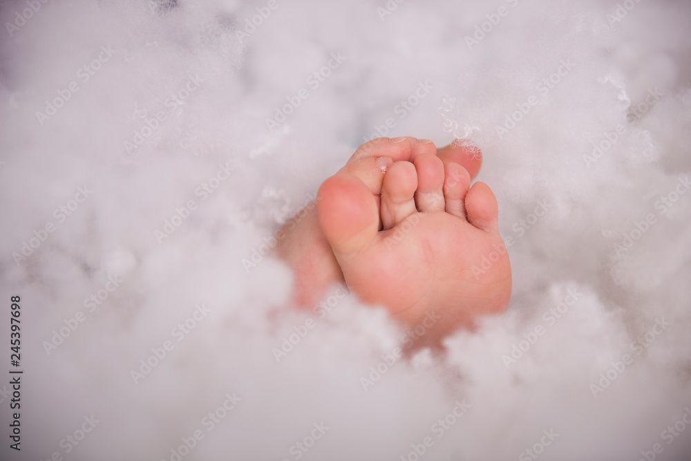 Fototapeta premium close up of cute small baby toes in a white cotton fool fluff 