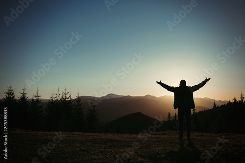 silhouette of a man in the mountains at sunset