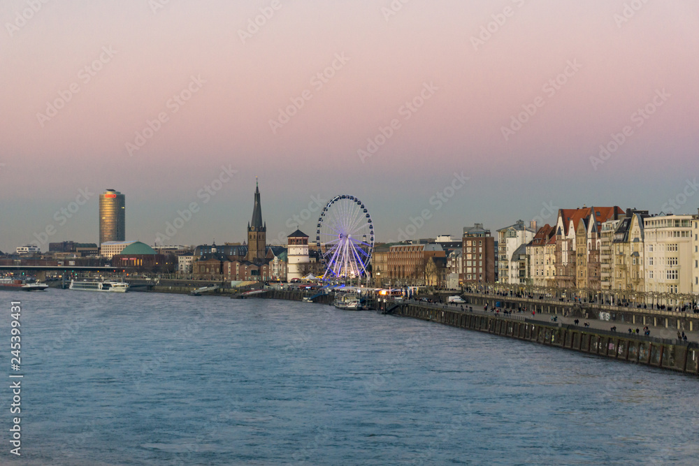 Duesseldorf, GERMANY - January 20, 2019: The Rhine promenade glooms during sunset and attracts many visitors