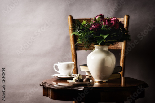 bouquet of flowers  on old coffee-table with old chair and book